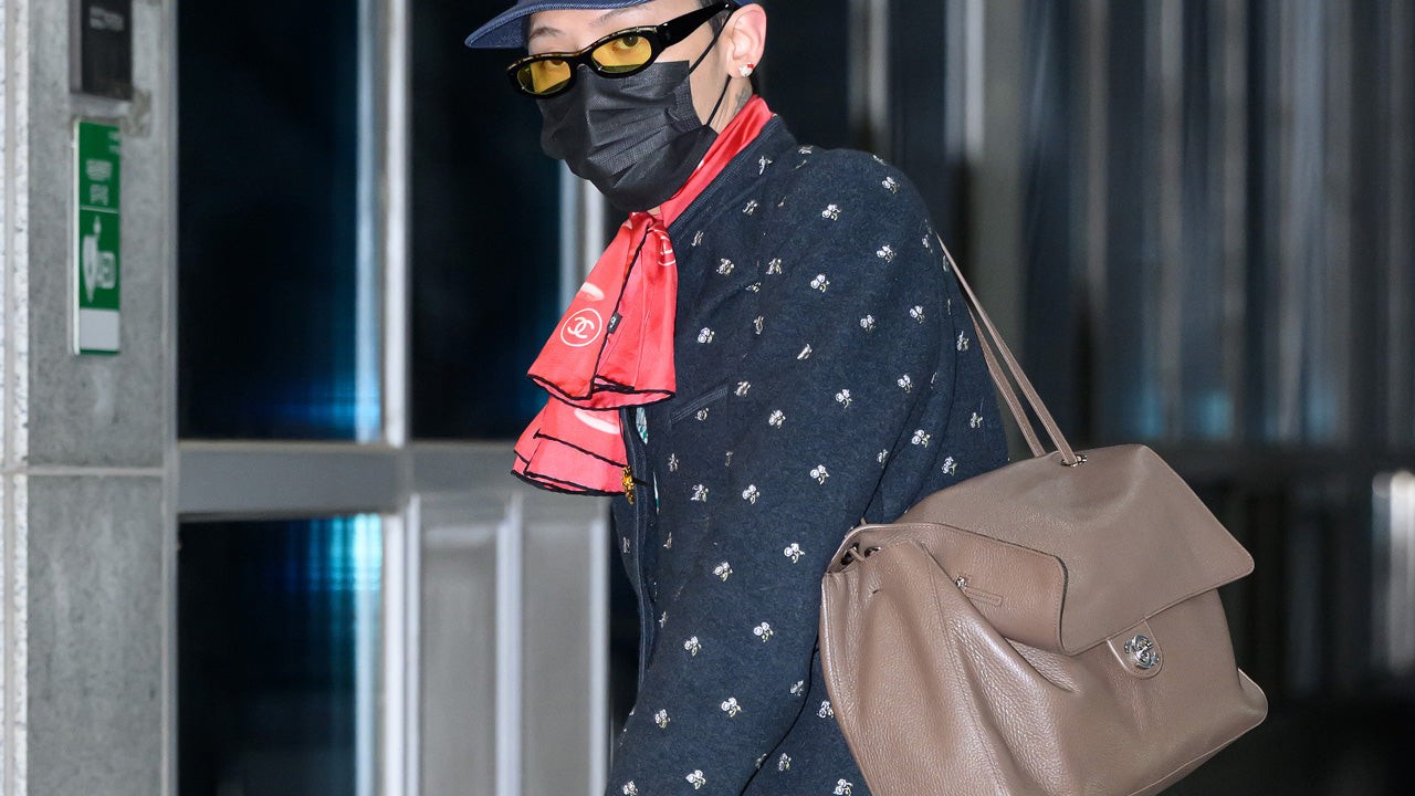 G-Dragon carrying Chanel's unquilted Maxi Flap bag in beige grained leather.