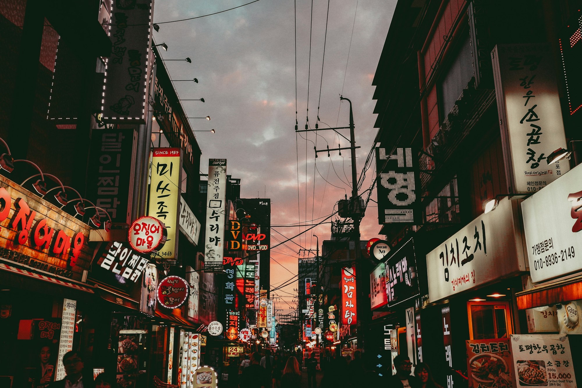 Seoul street at dusk with Hangul neon, the weekly culture pulse for diaspora group chats.