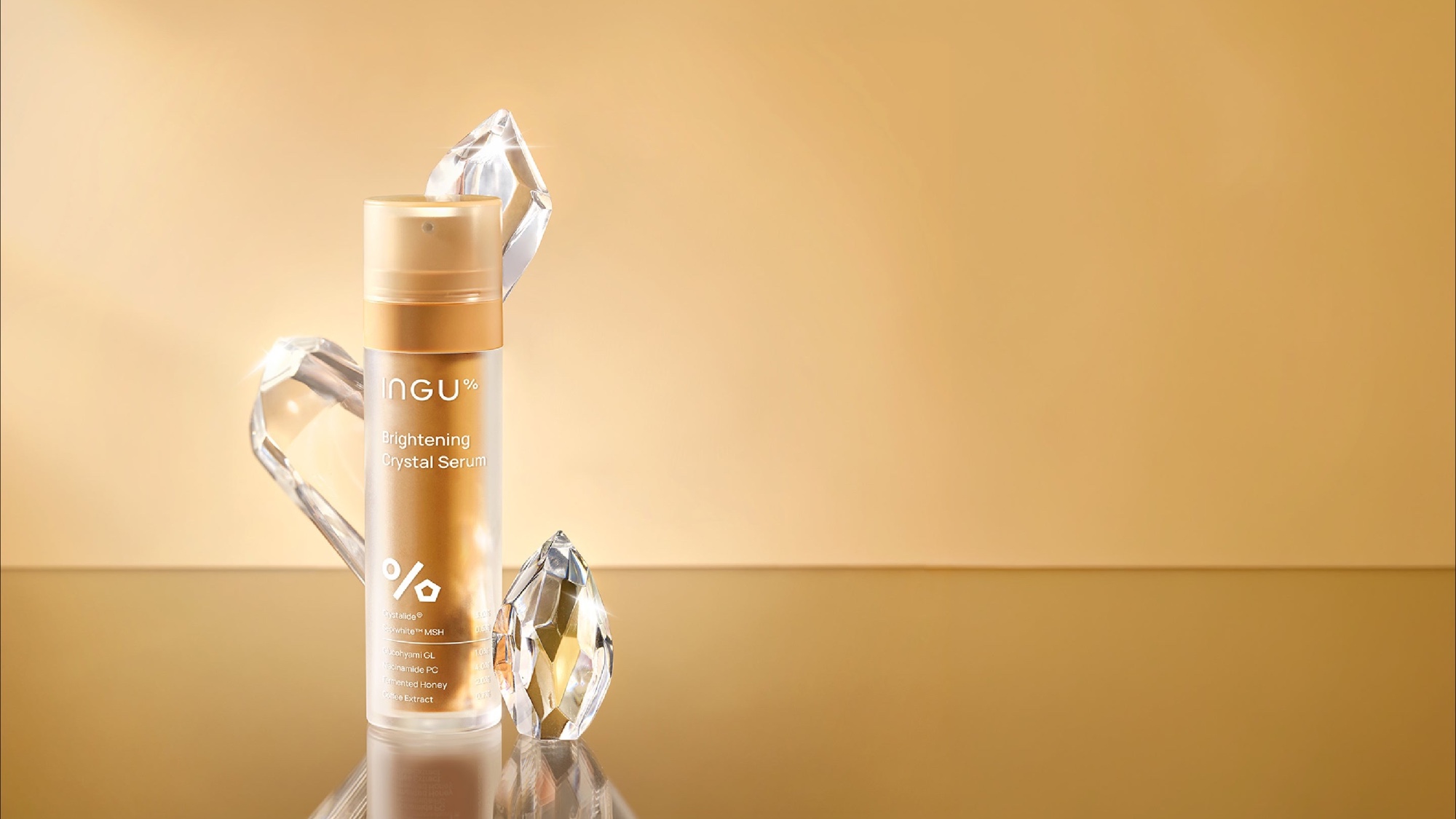 Ingu Skin Brightening Crystal Serum arranged with clear crystal forms against a warm gold background.