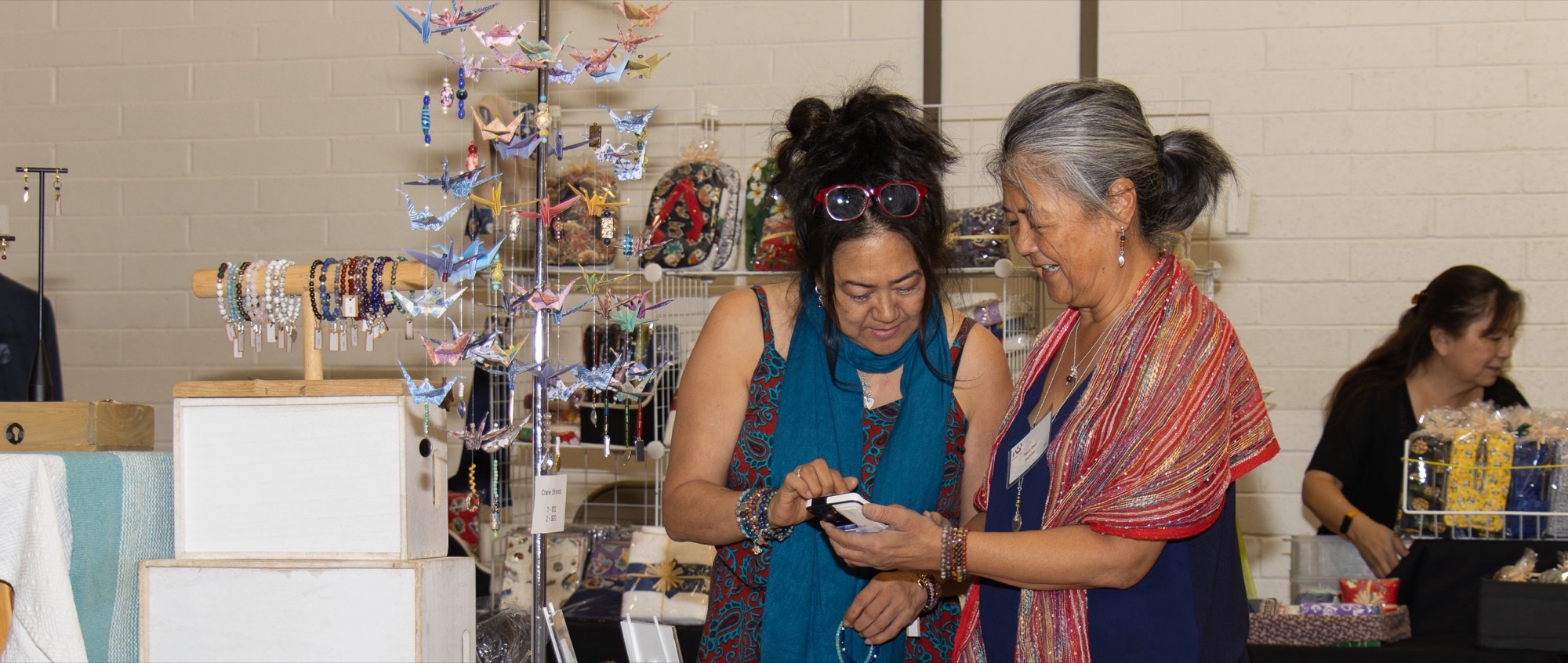Shoppers browse origami crane and jewelry displays at the Kokoro Craft Show.