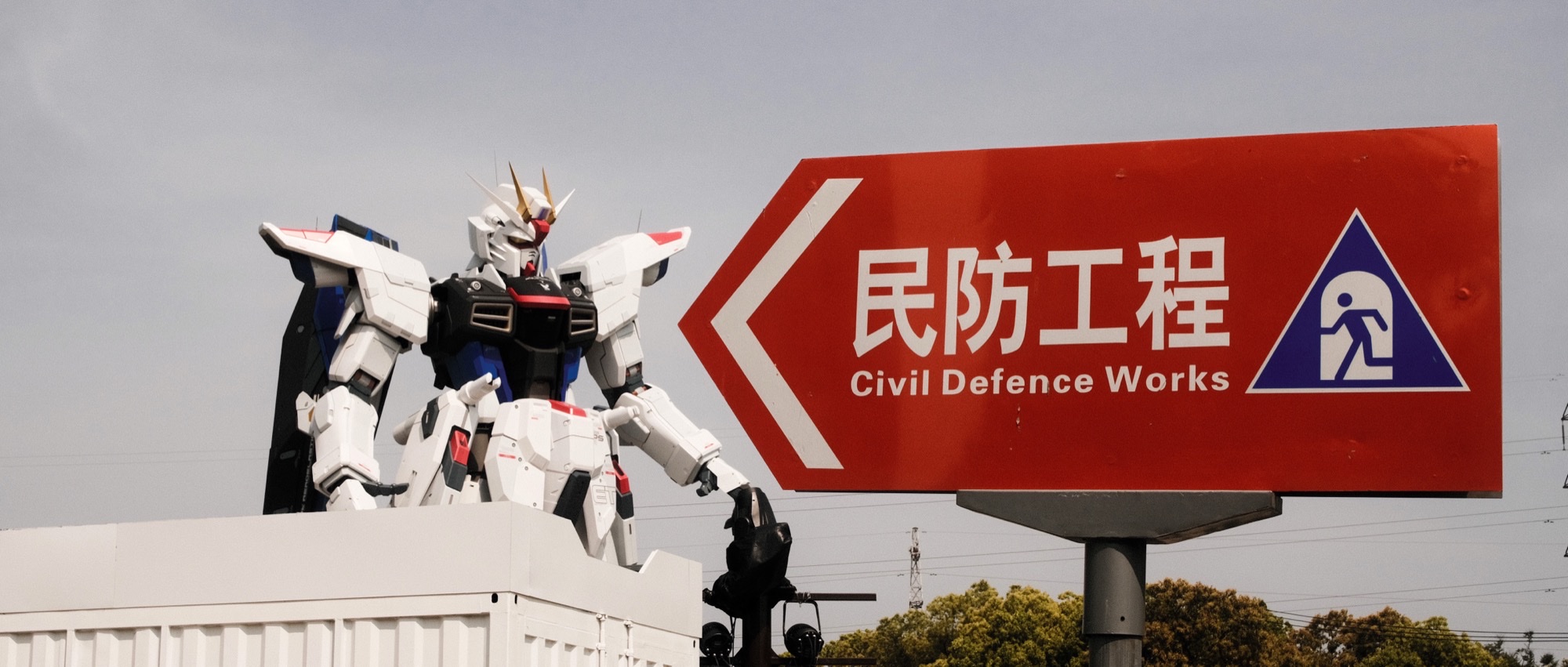 Large outdoor Gundam statue against a cloudy sky, a landmark image for Mobile Suit Gundam fandom.