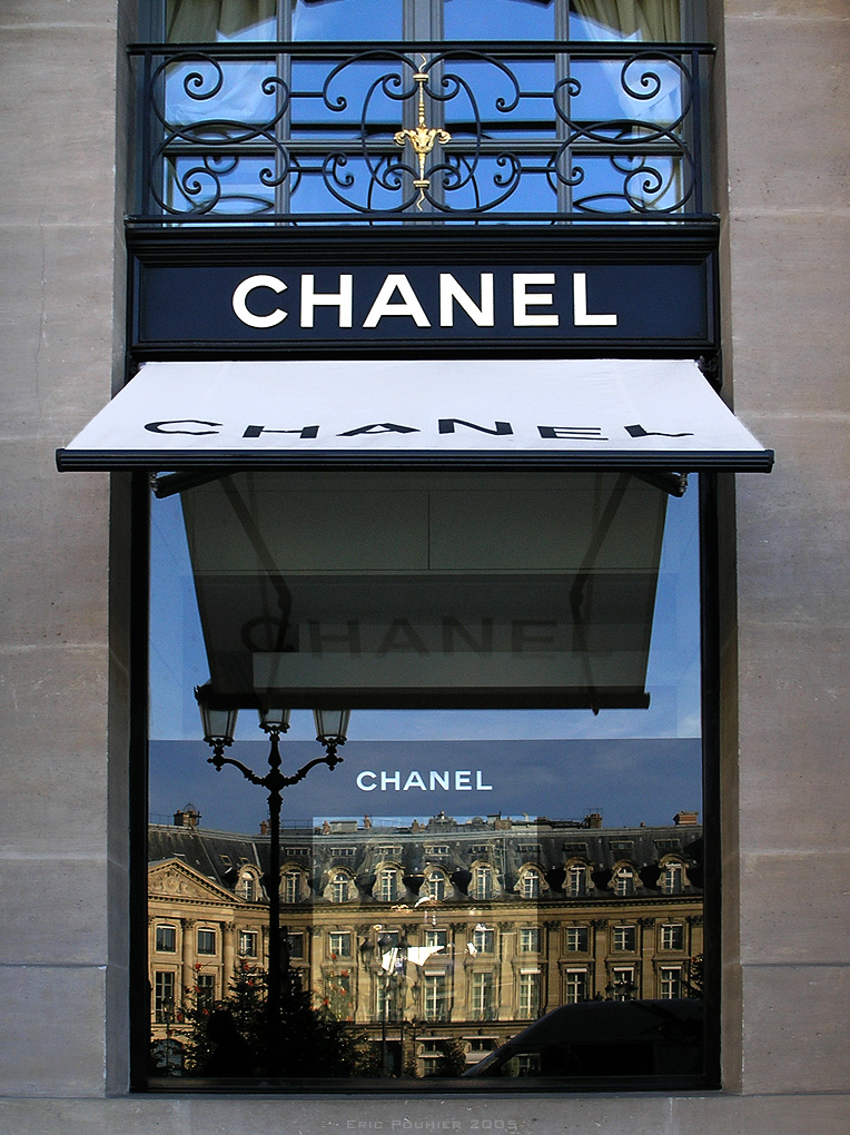 Context image: Display window of a luxury boutique with mannequins in tailored suits.