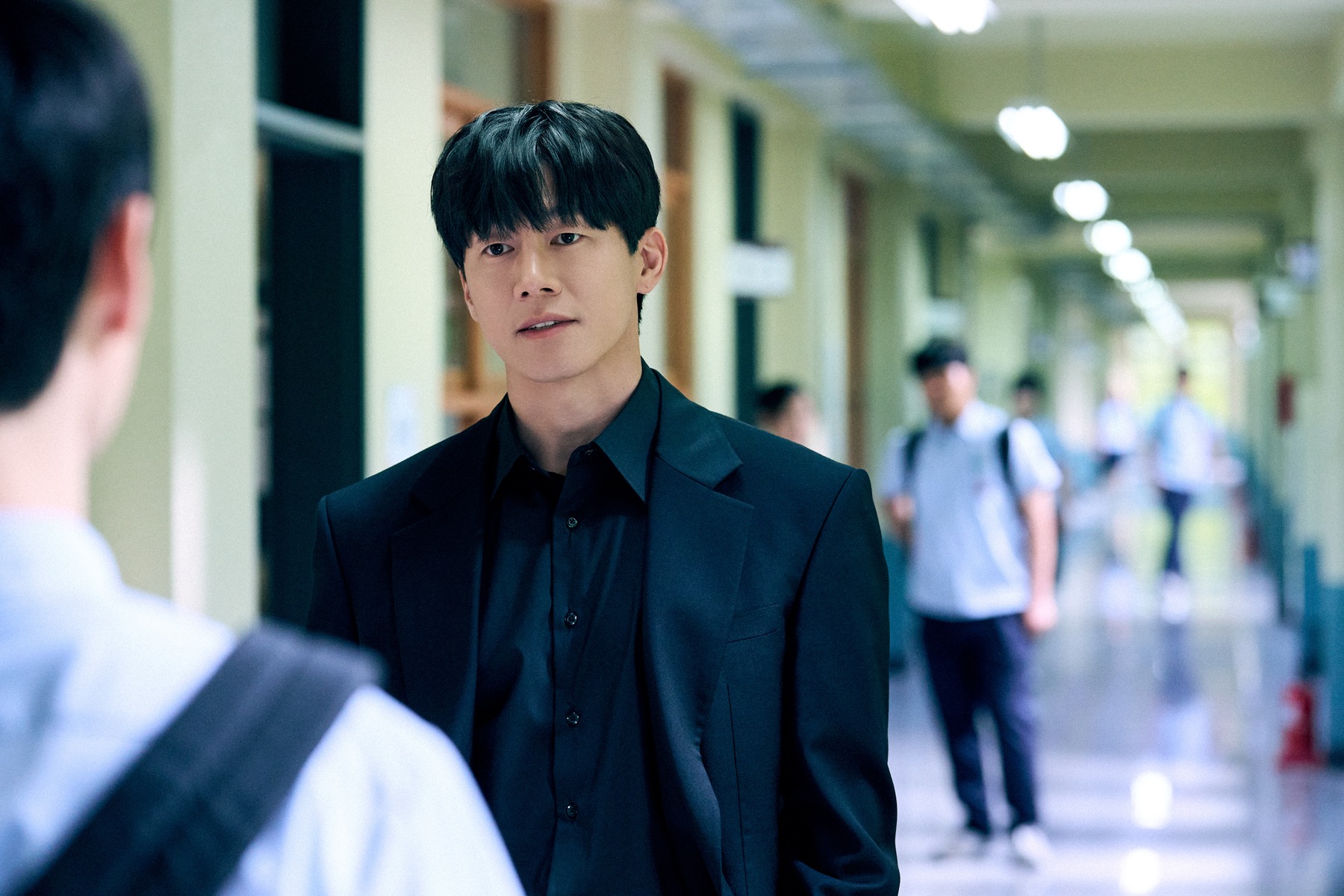 Kim Moo-yul as Na Hwa-jin in a school hallway in Netflix series Teach You a Lesson.