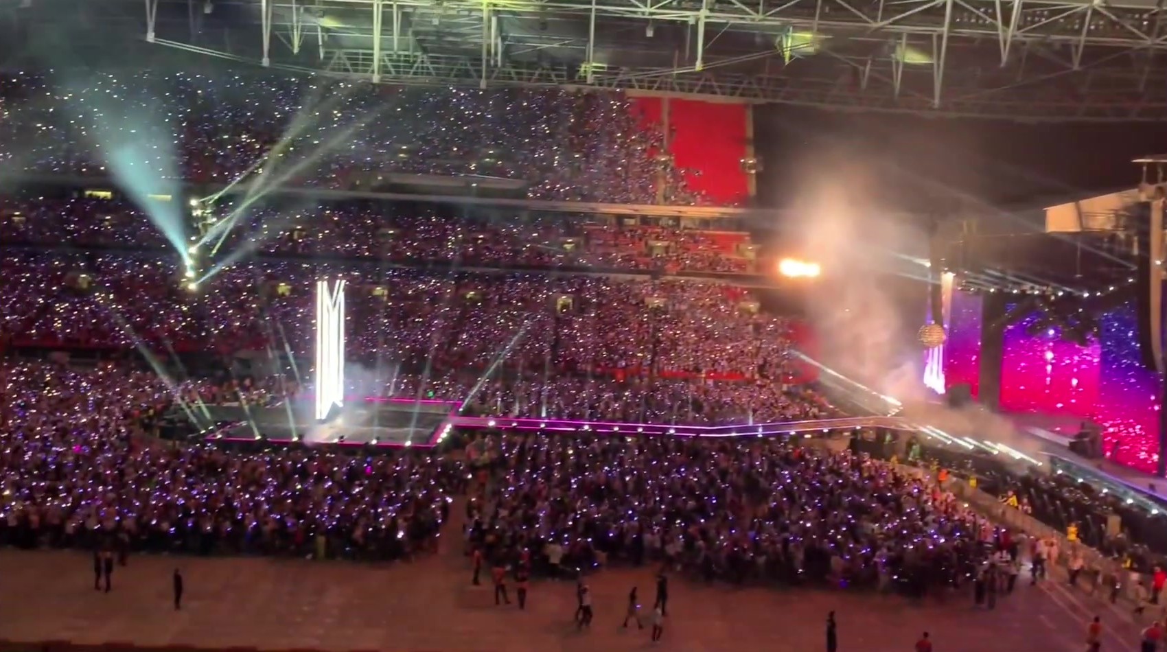Packed stadium for BTS Love Yourself: Speak Yourself at Wembley, with stage screens and a sea of ARMY lightsticks.