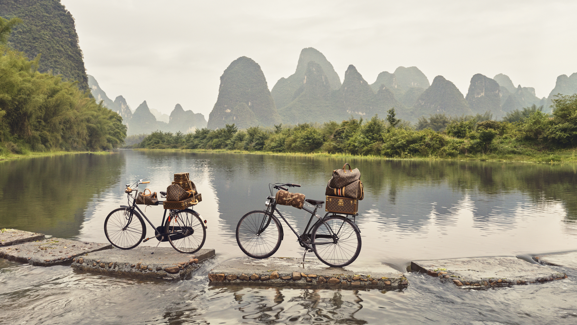 Louis Vuitton monogram luggage strapped to bicycles in Guilin, China, from the 2025 Spirit of Travel campaign.