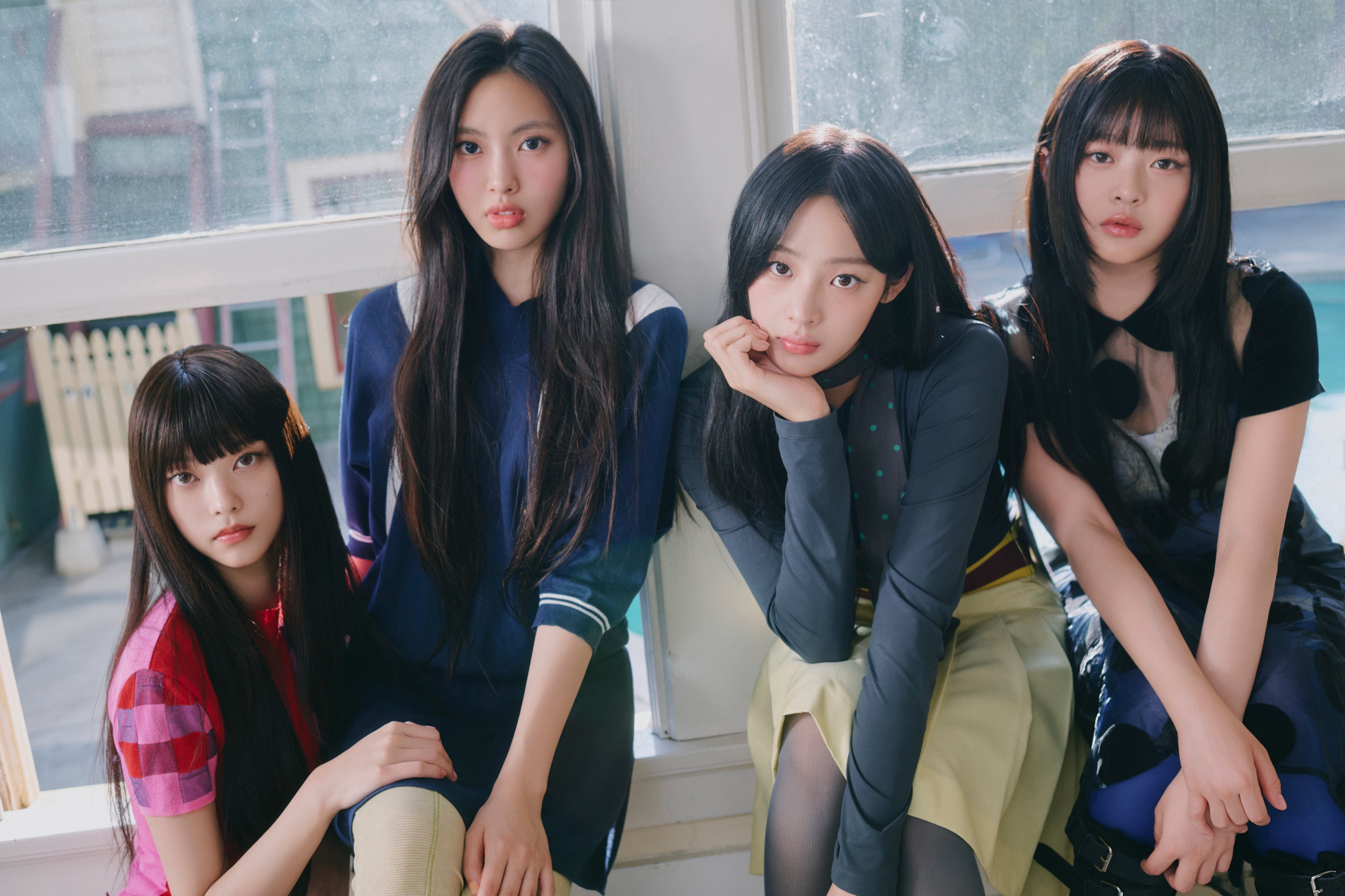 Minji, Hanni, Haerin, and Hyein of NewJeans seated together in a sunlit room for the 2026 Summer of NewJeans anniversary campaign.