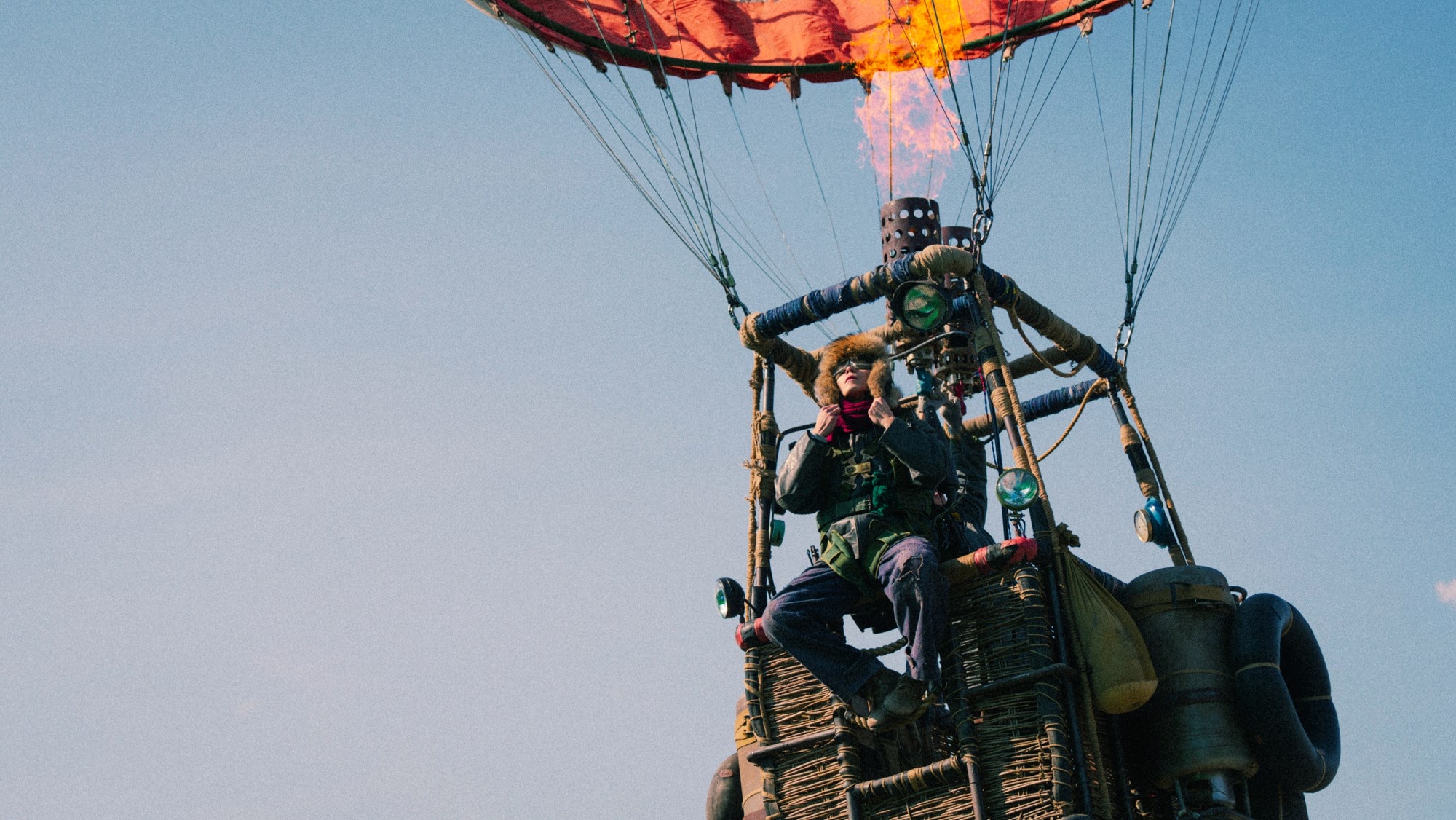 A factory worker rides beneath a burning hot-air balloon in Pengfei’s Chinese drama Take Off.