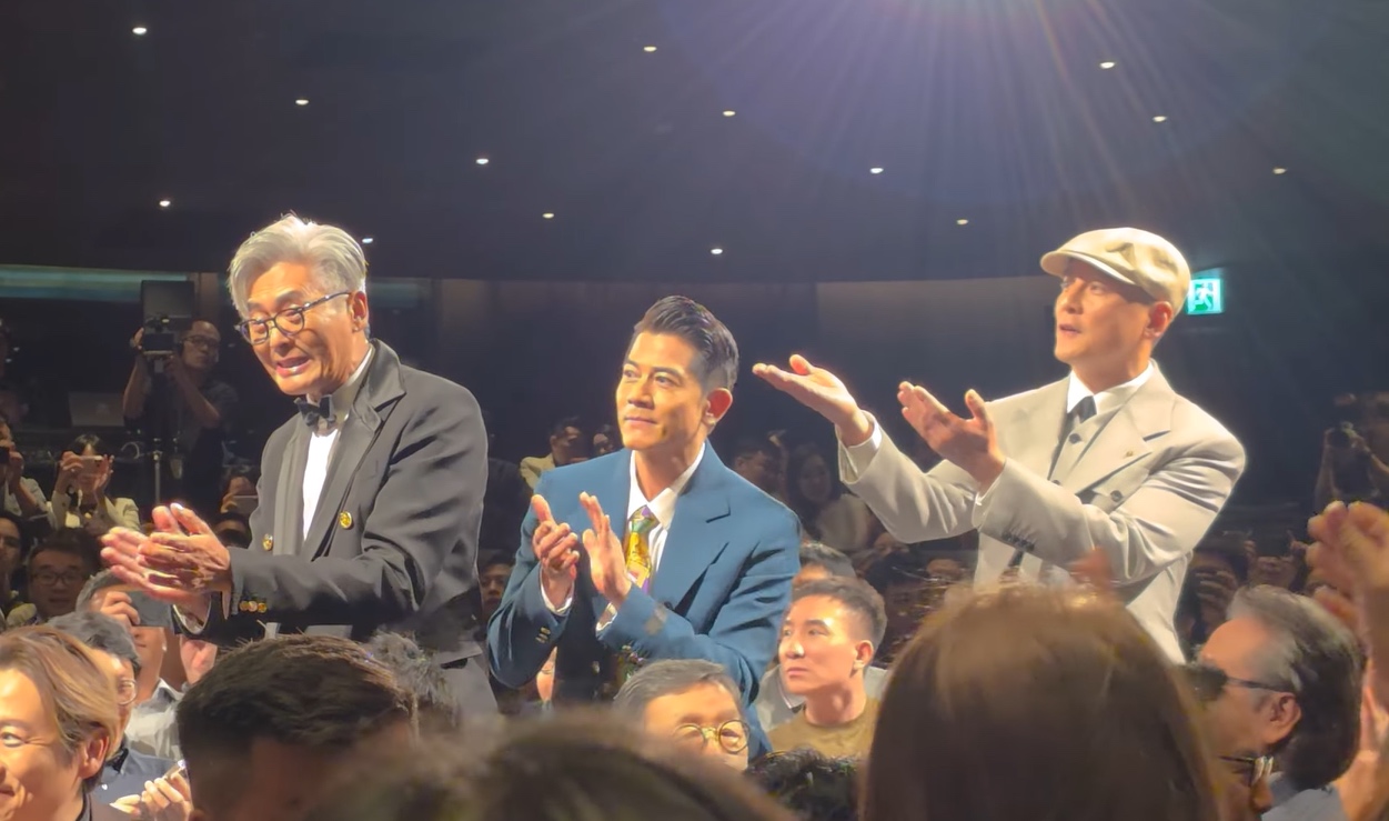 Daniel Wu in a grey suit and cap stands with Chow Yun-fat and Aaron Kwok at the Hong Kong premiere of Cold War 1994.