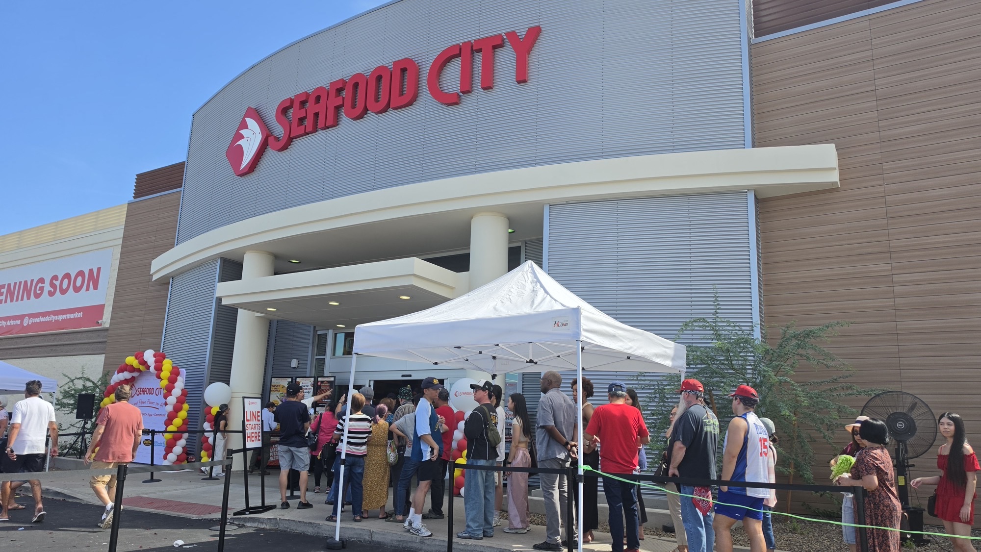 Crowds line up outside Seafood City at Chandler Fashion Center on opening day, under red Seafood City signage and balloon arches.