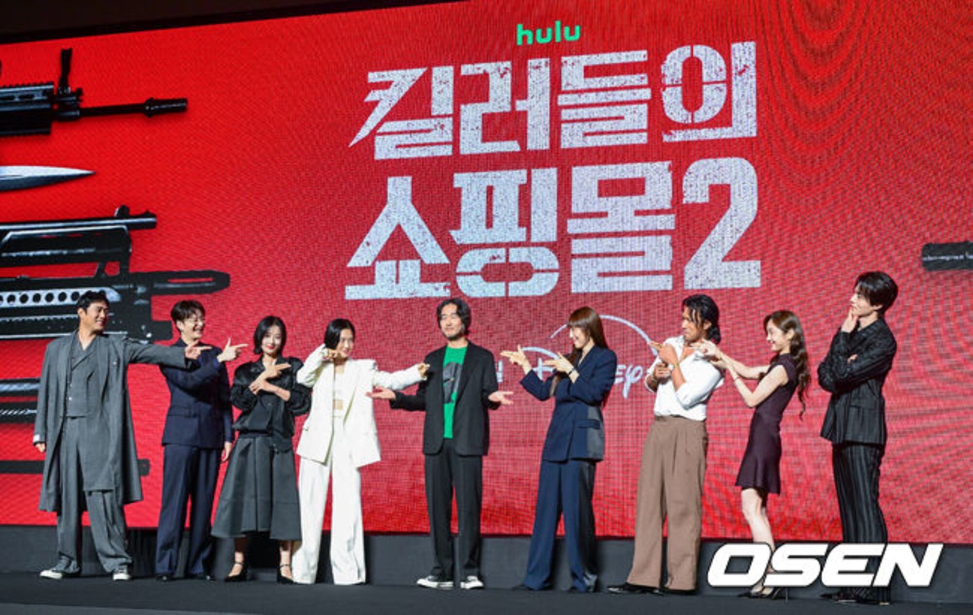 Lee Dong-wook, Kim Hye-jun, and the A Shop for Killers Season 2 cast posing at the Seoul production presentation against a red Disney+ and Hulu backdrop.