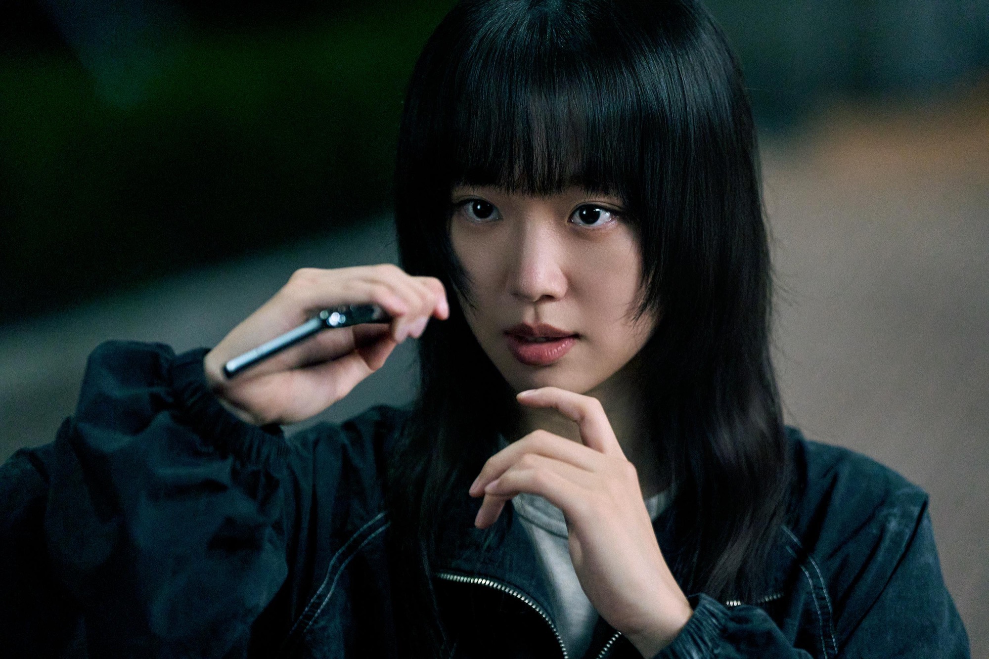 Jin Ki-joo as ERPB inspector Im Han-rim holds a phone outdoors at night in Netflix series Teach You a Lesson.