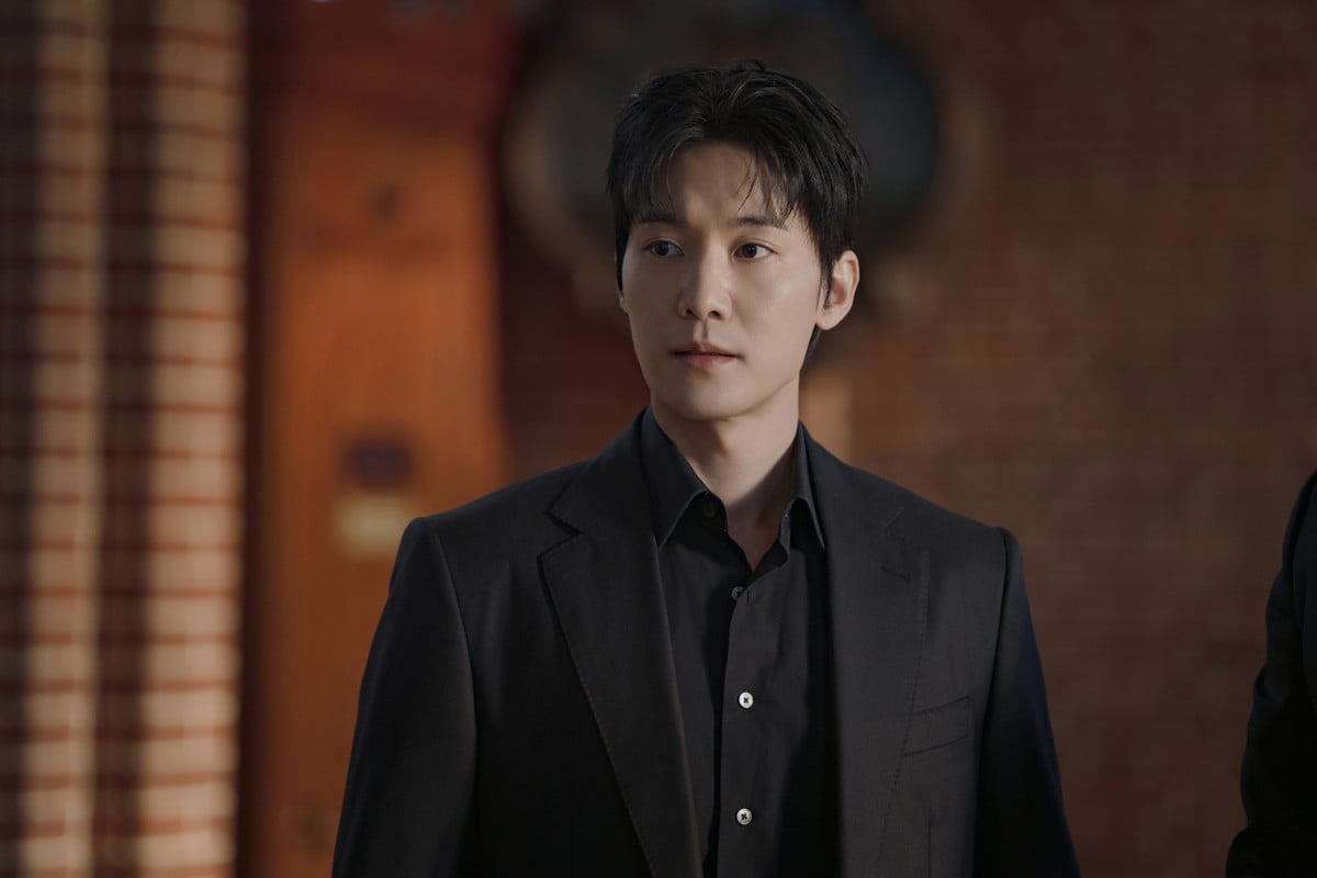 Ahn Hyo-seop in a dark suit looks off to the side in a still from Final Table.